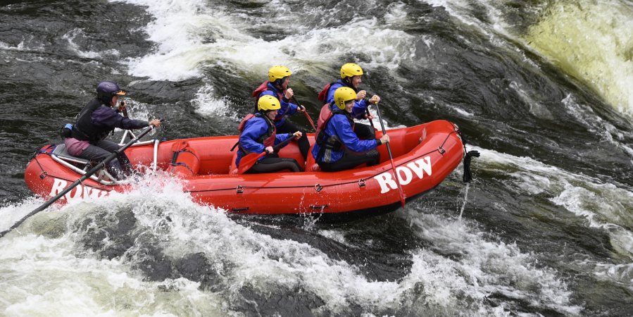 A red ROW branded raft full of passengers on the Lochsa River