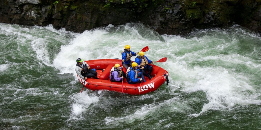 Birdseye view of a red raft moving through a whitewater rapid 